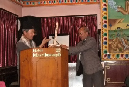 The Chairperson of the Nepal Esperanto Association receiving a small Peace Pole on behalf of the organization
