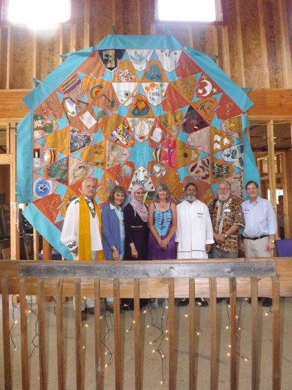 Pictured with the Peace Quilt (left to right): His Excellency Reverend Patrick McCollum, Ruth Broyde Sharone, Dina Shehata, M.A., Reverend Laura George, J.D., Guruji Sri Yogacharya Arun Kumarji, Glen T. Martin, Ph.D., and Reverend Don Lanksy